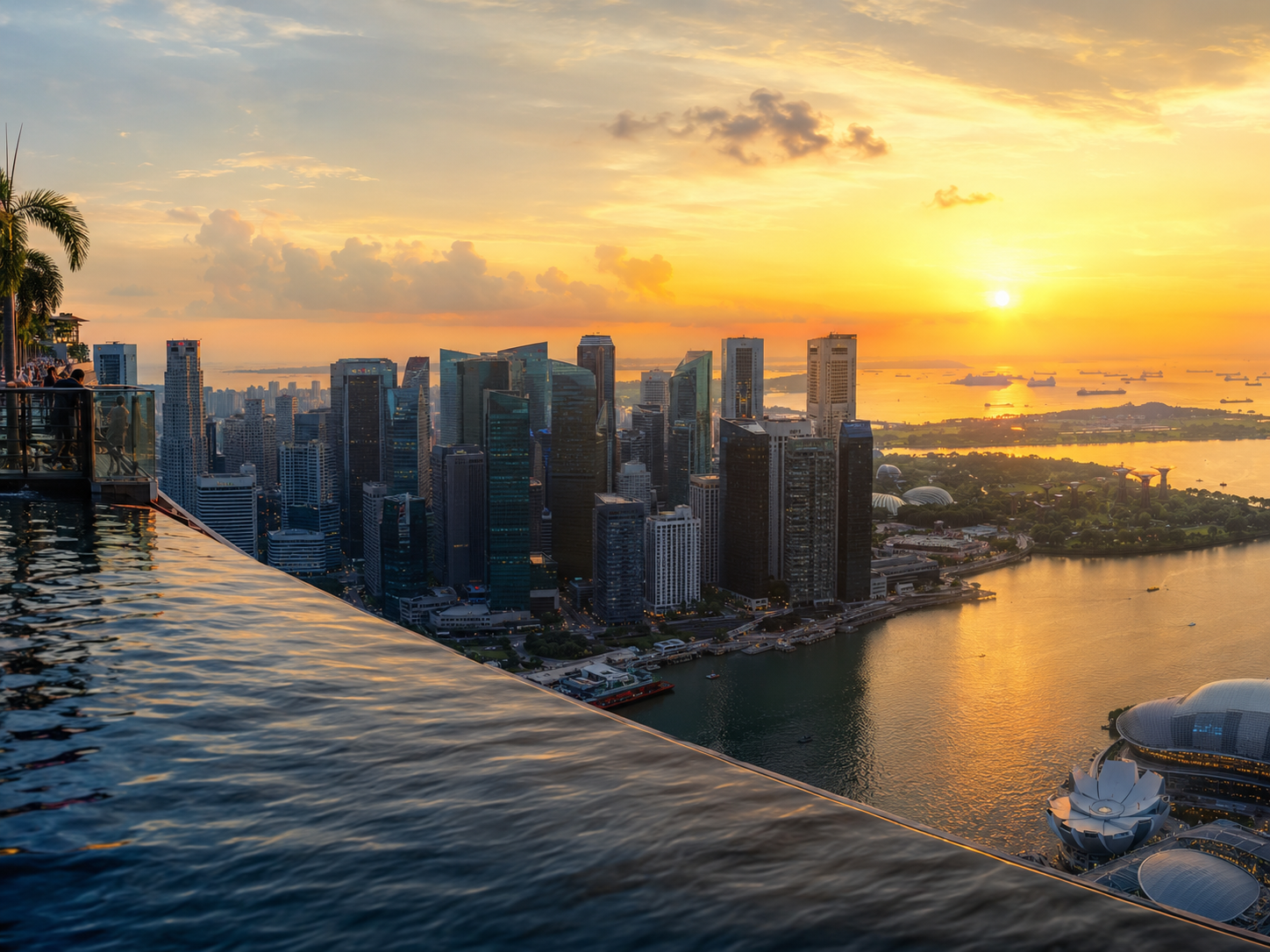 View from Marina Bay Sands SkyPark at sunset — CBD skyline, Supertrees, and Singapore Strait