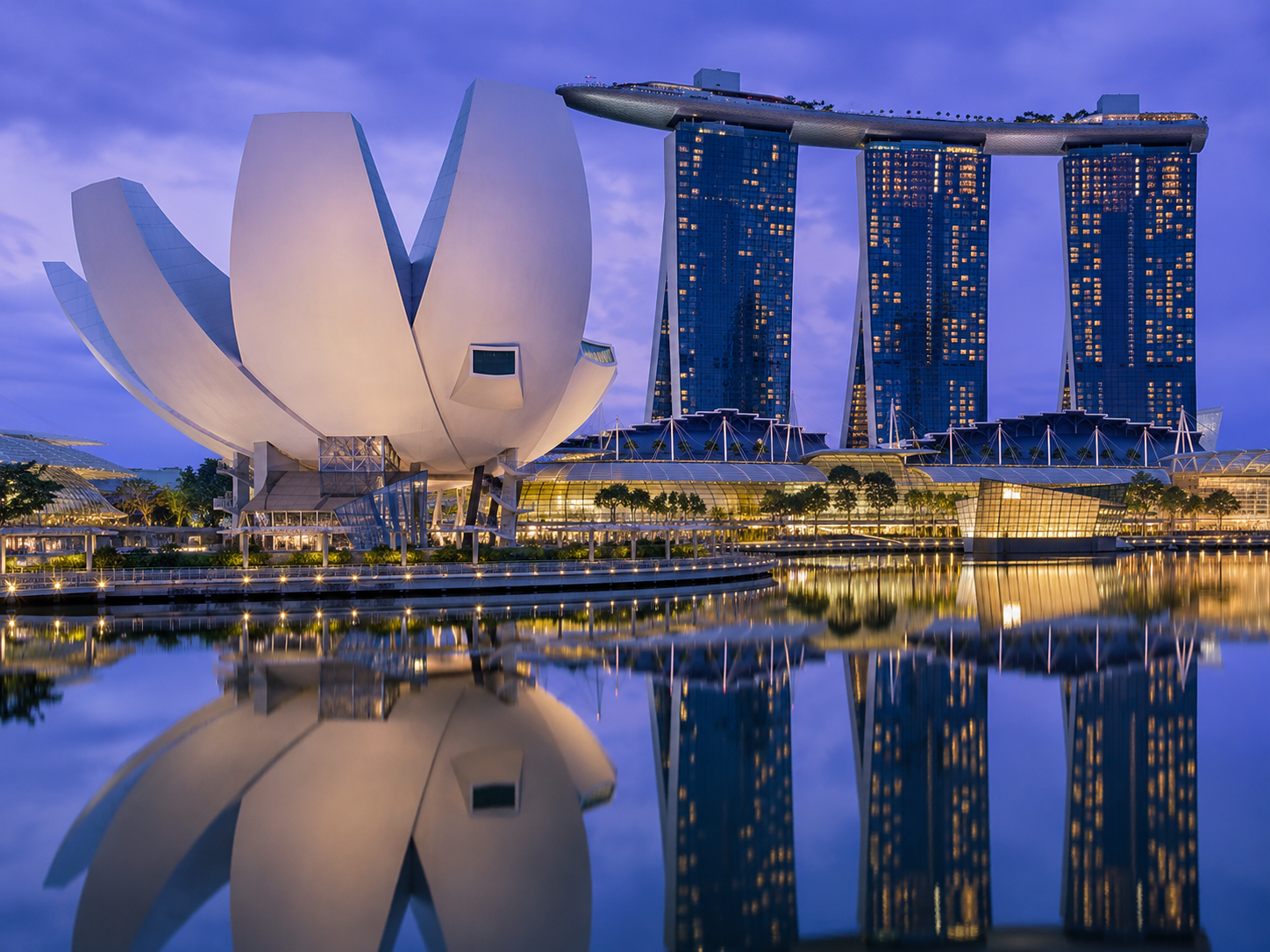 ArtScience Museum Singapore — lotus-shaped white building reflected in Marina Bay at dusk